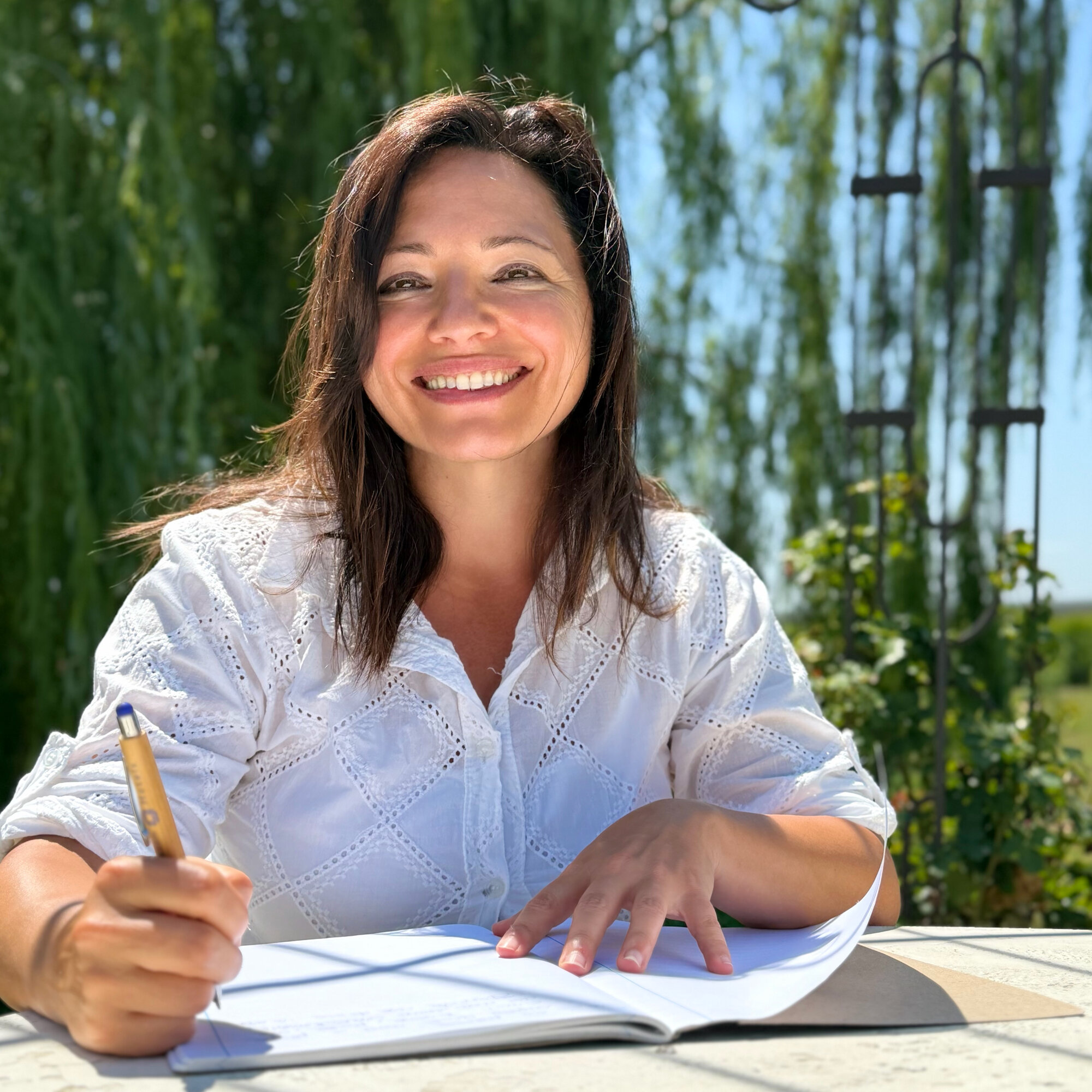 Silvia sorride con la penna in mano sul quaderno aperto: pronta ad ascoltare